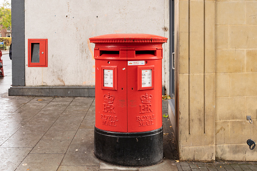 A red Royal Mail Post Box erected in the Reign of Queen Elizabeth the second. It is situated opposite Hinchingbrooke Hospital in Huntingdon, Cambridgeshire, England, UK.