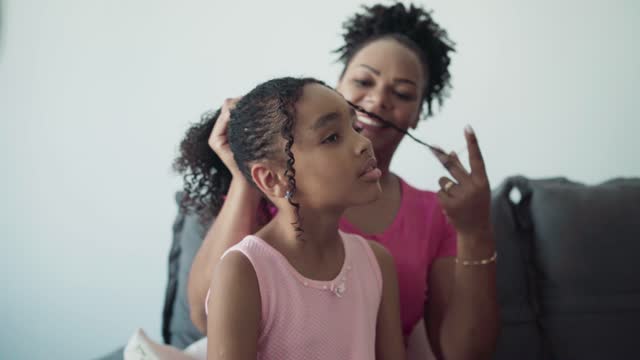 Mother combing daughter's hair