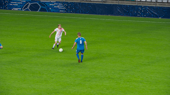 Football player jumping and heading ball towards goal.