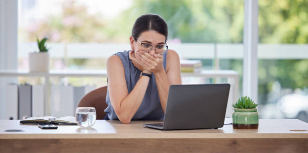 istock Surprise, mistake or error with a business woman looking shocked while working on a laptop in her office. Computer, glitch and problem with a scared female employee worried about a system failure 1480046585