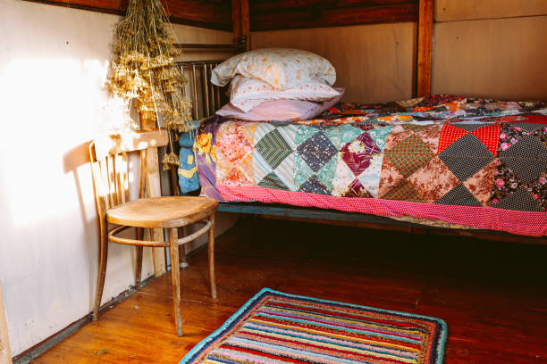 istock Bed with pillows and patchwork blanket in an old wooden house 1480047628