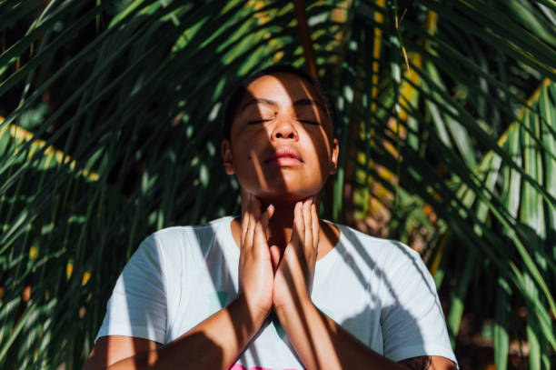 istock Woman looking serene surrounded by palm leaves 1480053303