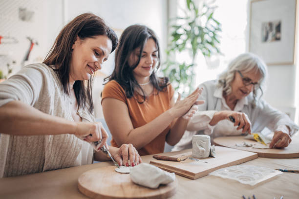istock Women molding clay together 1480061305