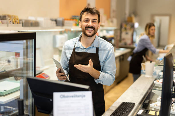 istock Smiling young  male baker at the checkout counter. 1480062810