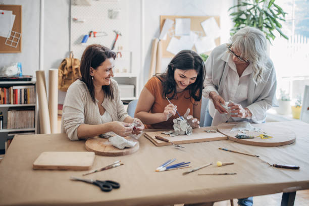 istock Women molding clay together 1480062826