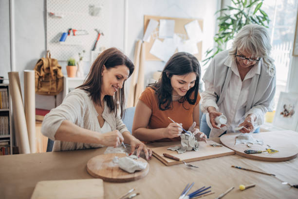 istock Women molding clay together 1480063846