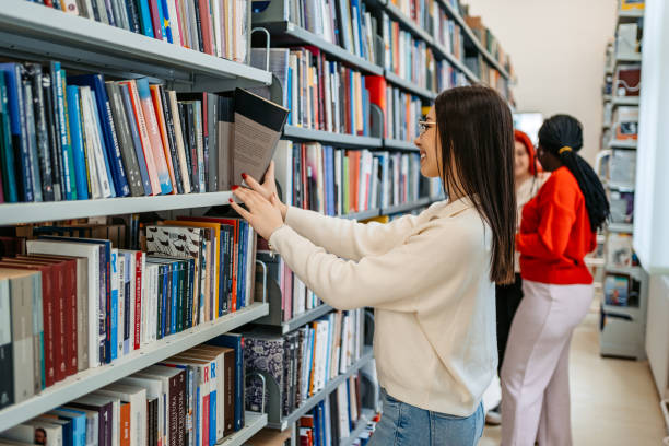 istock Female Student Picking Up A Book In A School Library 1480064185