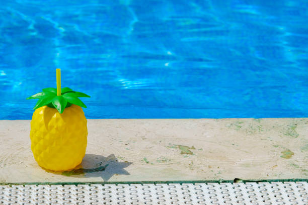 istock Yellow ananas cocktail cup at pool edge, high angle view 1480065936