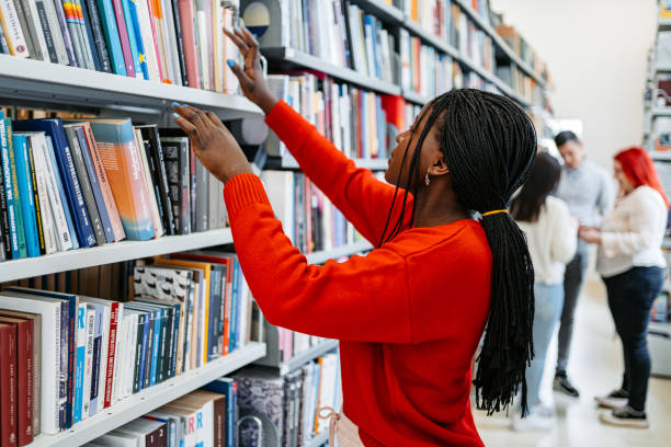istock Female Student Picking Up A Book In A School Library 1480067745