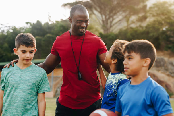 istock Happy coach standing with his elementary school rugby team 1480069469