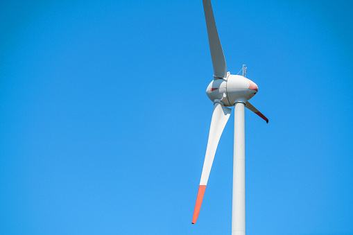 Wind turbine against blue sky. Renewable energy concept.