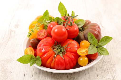 assorted of colorful fresh tomatoes and basil