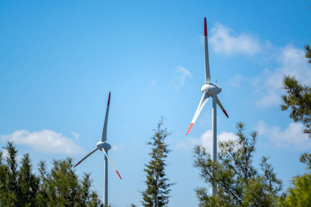 Wind turbine in mountains against blue sky. Renewable energy concept.