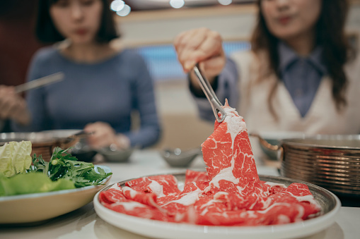 Two Taiwanese women went to a restaurant together to enjoy Chinese hot pot.
