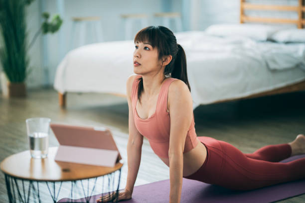 istock A female Asian is exercising at home, using a tablet for online training courses. 1480080562