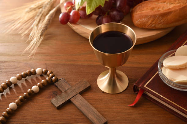 copa de vino y hostias consagradas en mesa de madera - consecrated fotografías e imágenes de stock