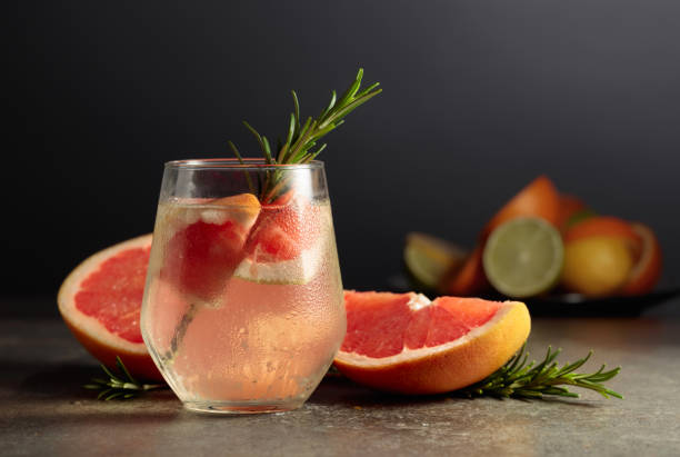 istock Cocktail gin tonic with ice, rosemary, and grapefruit on a stone table. 1480084858