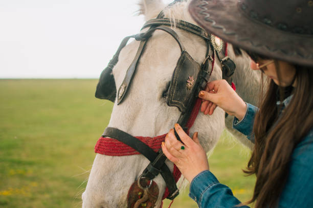 istock Attaching the bridle to her horse 1480091838