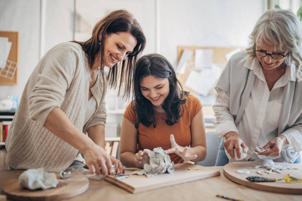 istock Women molding clay together 1480094094