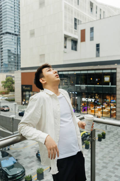 On a cloudy day in Shangcheng, Shenzhen City, Guangdong Province, a male businessman rested on a balcony outside the company, drinking coffee - drinking a cup of coffee after work to promote health and work life balance en un día nublado en shangcheng, ciudad de shenzhen, provincia de guangdong, un hombre de negocios descansó en un balcón fuera de la empresa, bebiendo café, bebiendo una taza de café después del trabajo para promover la salud y el equilibrio entre la