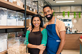 Entrepreneurial couple looks at camera and smiles in grocery store