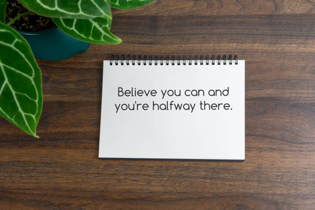 istock Short inspirational quotes text on note pad - Believe you can and you're halfway there. 1480096314