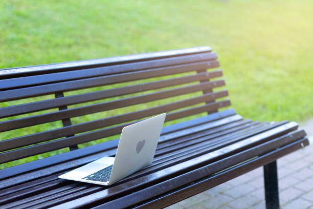 istock A gray laptop lies on a park bench. 1480100323