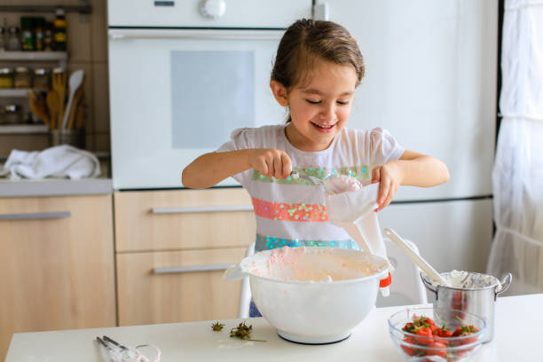 istock Little girl having fun with piping bag in the kitchen 1480101193