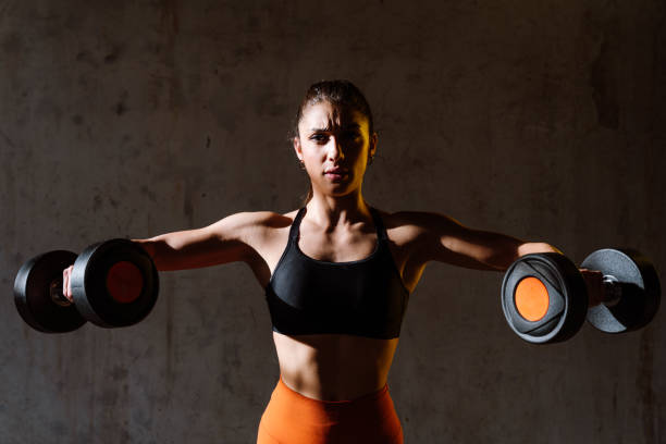 Young female athlete training in a gym using sport equipment