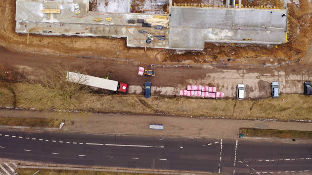 istock Drone photography of unloading semi truck with a forklift in a construction site during spring cloudy morning. 1480101640