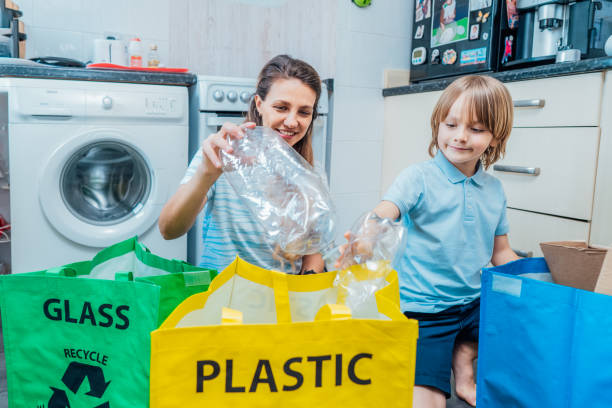 istock Mother is teaching kid how to recycle help the boy aware environmental importance - mom educates son sort garbage into different bins on kitchen. Family sorting garbage at home. Concept of recycling 1480102723