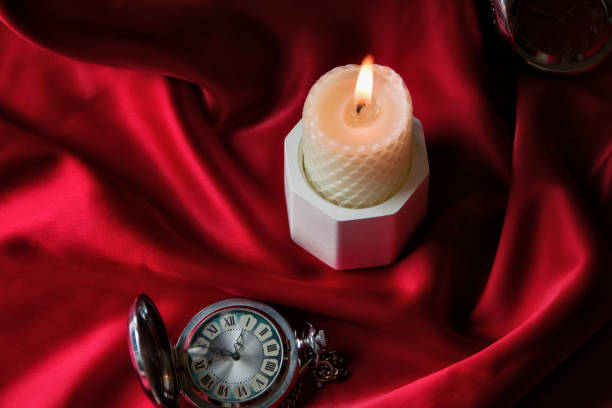 istock White burning candle on a red background with an old pocket watch, postcard on a blue background. Table decor for a festive dinner, Witchcraft, esoteric spiritual ritual. autumn equinox festival 1480104811