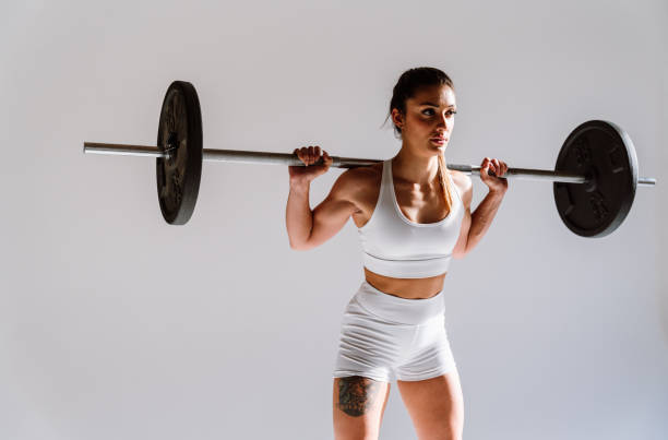 Young female athlete training in a gym using sport equipment