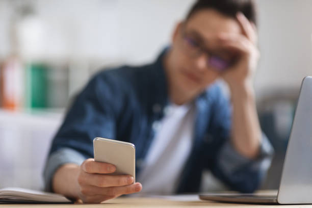 istock Young Male Employee Using Modern Smartphone While Sitting At Desk In Office 1480106751