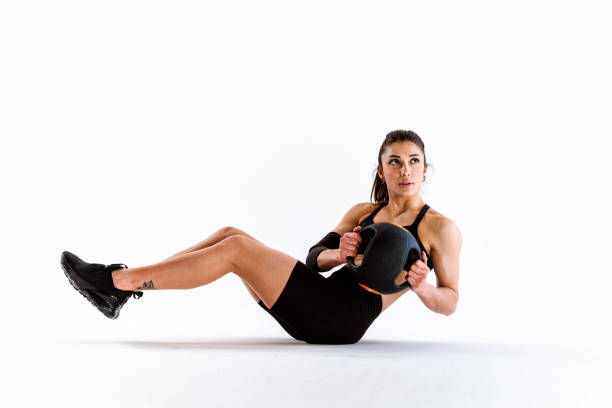 Young female athlete training in a gym using sport equipment