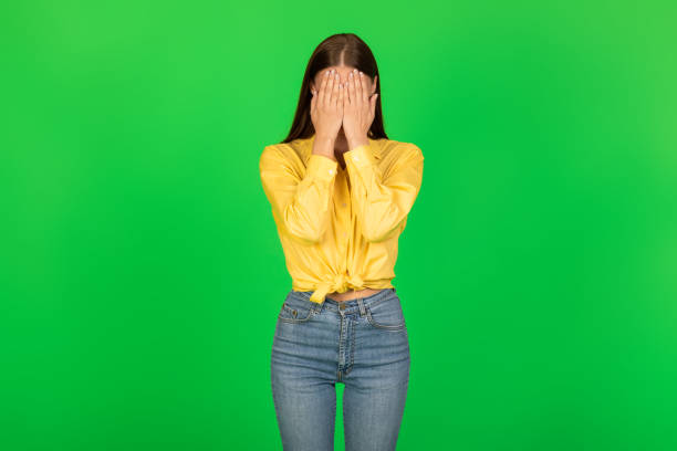 istock Unrecognizable Lady Covering Face Posing Standing Over Green Studio Background 1480107036