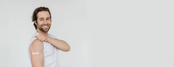 istock Glad millennial caucasian guy with stubble shows shoulder with band-aid isolated on white background 1480107292