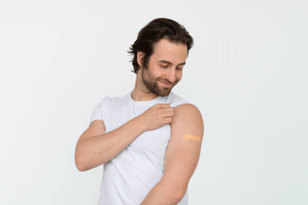 istock Smiling glad young caucasian guy looking at band aid on shoulder after vaccination 1480107638