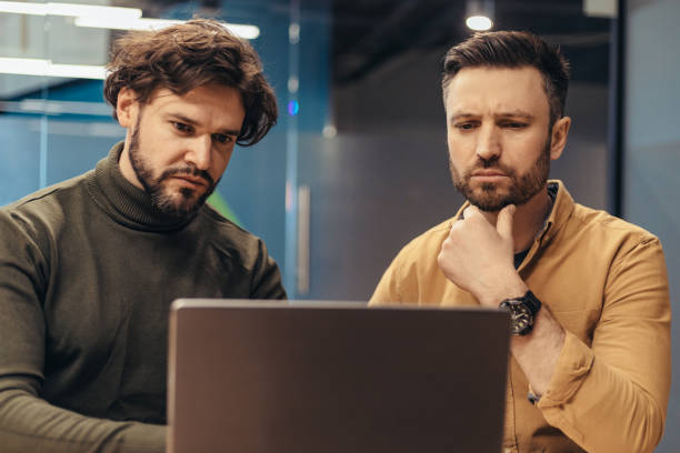 istock Two male employees developing business strategies, coworking together, using laptop pc at office 1480107907