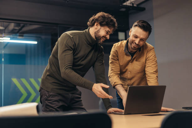 istock Positive male employees discussing business project, using laptop, brainstorming for ideas at company office 1480108089