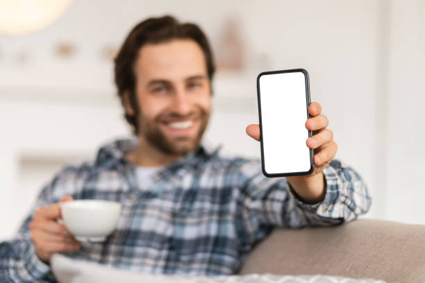 istock Happy millennial european man with stubble shows phone with empty screen, recommend website 1480108208