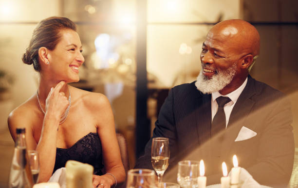 homme ou femme noir heureux et drôle dans une célébration festive d’objectifs ou de nouvelle année lors d’un événement social de luxe. amis, félicitations ou personnes âgées qui rient, créent des liens ou parlent au dîner de gala en vacances - champagne flute champagne black wineglass photos et images de collection