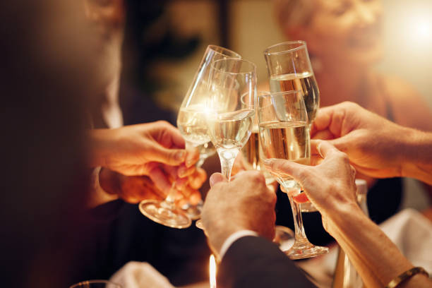 sukces, ręce lub toast na imprezie za cele, zwycięską umowę lub nowy rok na luksusowym wydarzeniu towarzyskim. motywacja, praca zespołowa lub ludzie wiwatujący z napojami szampana lub kieliszkami wina podczas uroczystej kolacji - toast party champagne dinner zdjęcia i obrazy z banku zdjęć