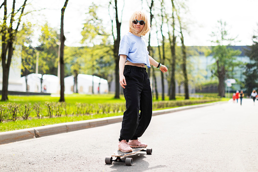 Young adult hipster woman on longboard