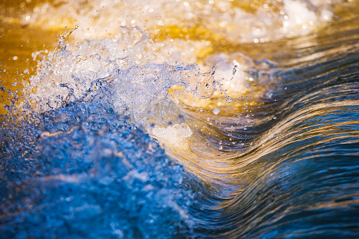 Miniature macro wave breaking on shoreline with stunning detail. Abstract ocean theme.