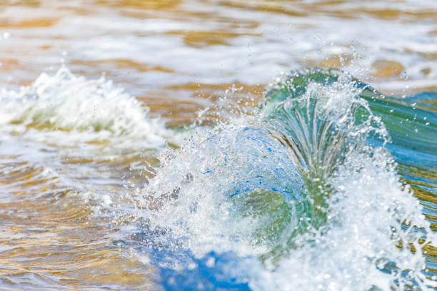 Miniature macro wave breaking on shoreline with stunning detail. Abstract ocean theme.