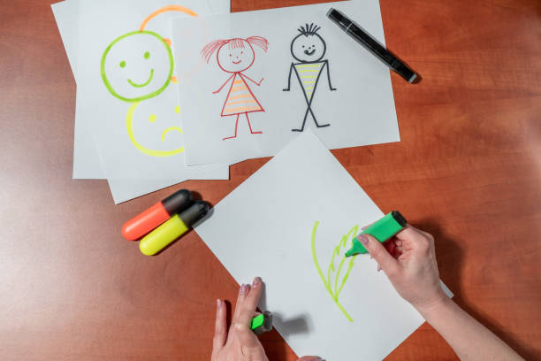 istock Women's manicured hands draw with felt-tip pens on a white sheet. At the desk. Top view 1480111791
