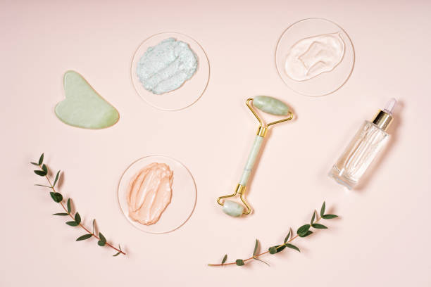istock Cosmetic background roller for the face, anti-aging scraper guasha eucalyptus leaves. Pastel pink background skin care set. 1480116616