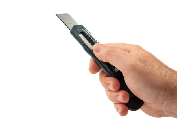 istock Holds a box cutter in his hand on a white background. 1480116874