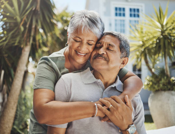 Senior, couple and old man and woman hug with love, care and support outside their home or house. Lovers, pensioner and elderly people enjoying retirement together with happiness in marriage stock photo